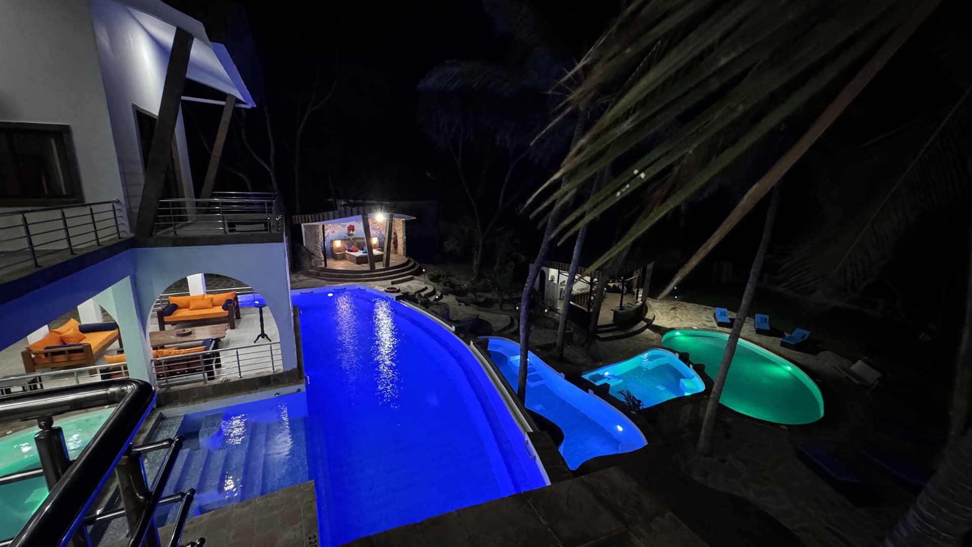 Cascading waterfall pools at night with illuminated outdoor area at Rozzie's Beach Villa